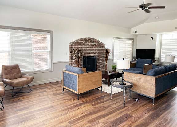 A clubhouse with a brick fireplace and a couch at Fieldstream Apartment Homes in Ankeny, IA
