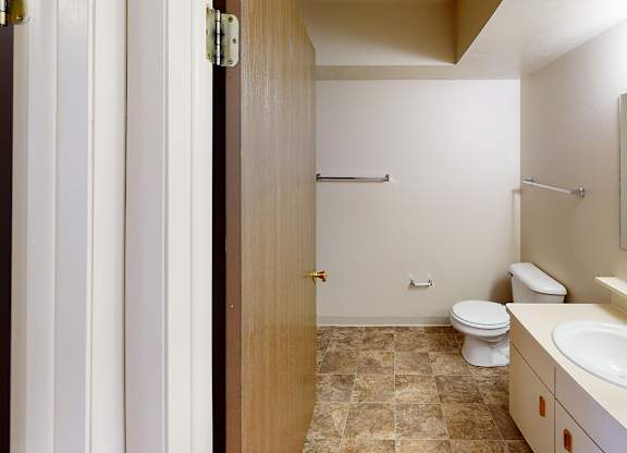 A bathroom with a toilet, sink, and a bathtub at Foxwood and The Hermitage, Portage, MI, 49024