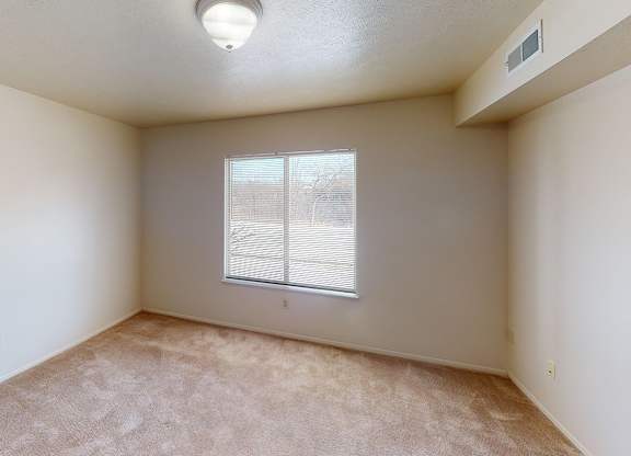 A bedroom with a window and carpeted floor at Foxwood and The Hermitage, Portage, MI