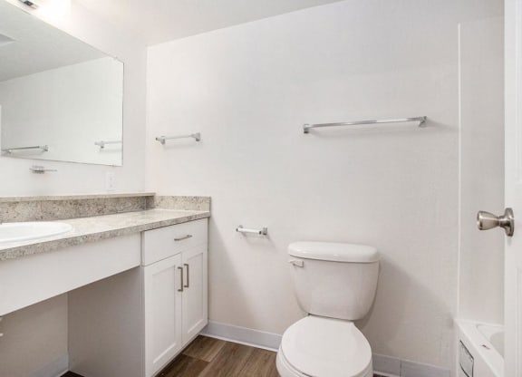 an upgraded bathroom with a toilet and a sink and a mirror at Glenn Valley Apartments in Battle Creek, MI