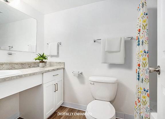 A modern bathroom with a vanity and large mirror at Glenn Valley Apartments in Battle Creek, MI