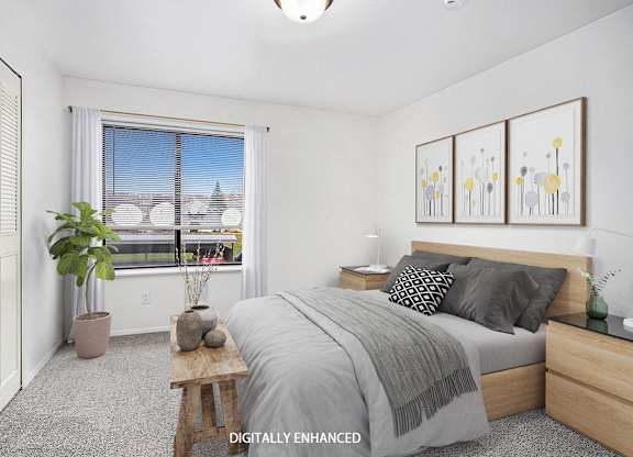 A bedroom with a large window, bed, and a closet at Glenn Valley Apartments in Battle Creek, MI
