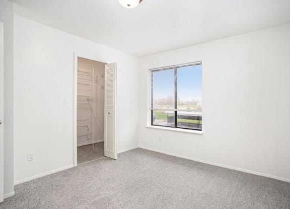 a bedroom with a large window and a walk in closet at Glenn Valley Apartments in Battle Creek, MI