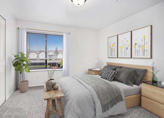 A bedroom with a large window, bed, and a closet at Glenn Valley Apartments in Battle Creek, MI