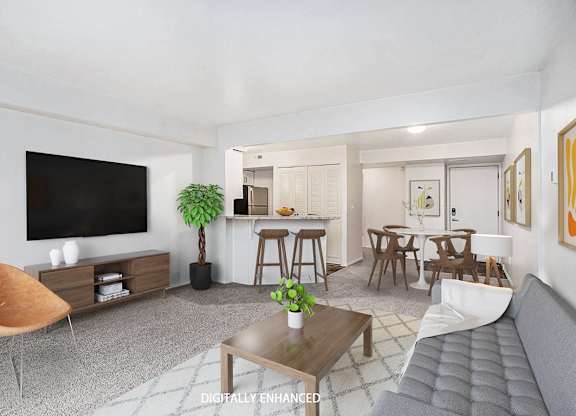 A living room with a grey sofa, wooden coffee table, and a television at Glenn Valley Apartments in Battle Creek, MI