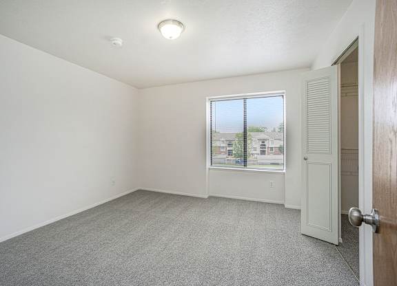 Bedroom with a closet and a window at Glenn Valley Apartments, Battle Creek