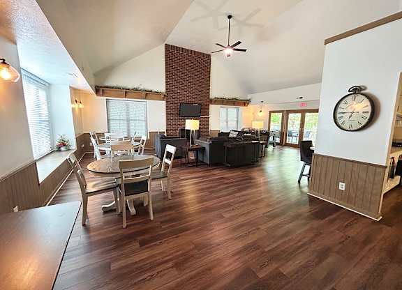 A large community room with a hard-surface floor and a brick fireplace wall at Glenn Valley Apartments in Battle Creek, MI