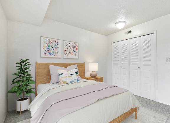 A bedroom with a large closet, bed, and a potted plant at Granada Apartments, Jackson, 49202