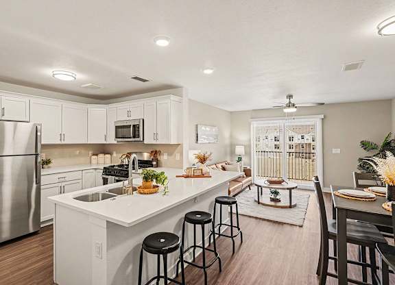 A kitchen with white cabinets and a stainless steel refrigerator at The Grove Apartment Homes, Nebraska