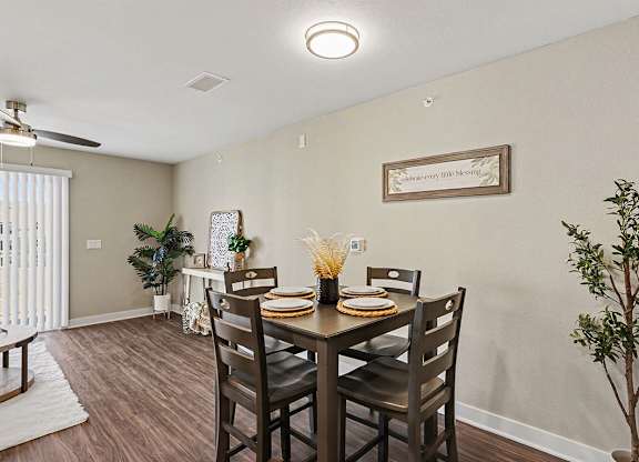 A dining room with a table set for four and a plant on the side at The Grove Apartment Homes, Nebraska