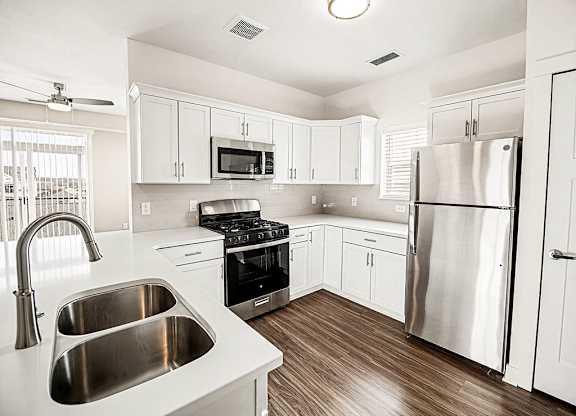 A kitchen with white shaker cabinets and stainless steel appliances at The Grove Apartment Homes in Lincoln, NE