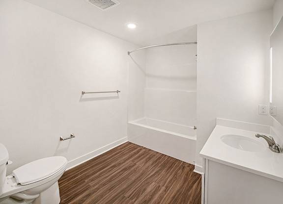 A white bathroom with hard-surface flooring at The Grove Apartment Homes in Lincoln, NE