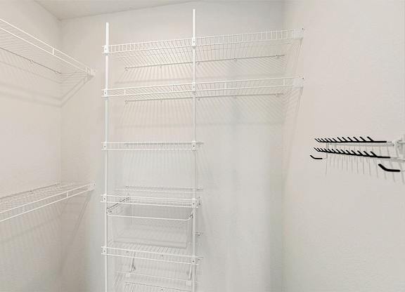 A walk-in closet with wardrobe organizers at The Grove Apartment Homes, Nebraska, 68512