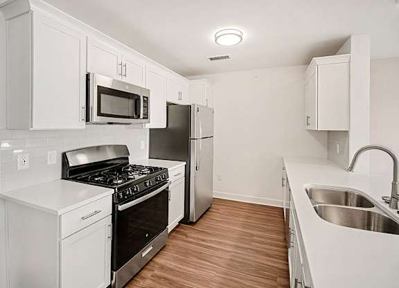 A kitchen with white cabinets and stainless steel appliances at The Grove Apartment Homes in Lincoln, NE