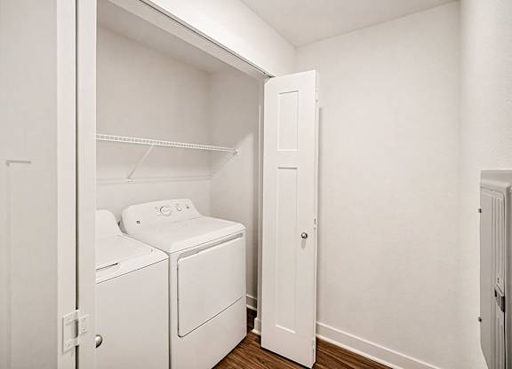 A white laundry area with a washer and dryer at The Grove Apartment Homes in Lincoln, NE