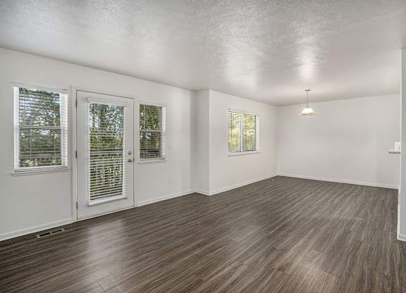 living room with hard surface floors and a door to a balcony at Gull Prairie/Gull Run Apartments and Townhomes, Kalamazoo