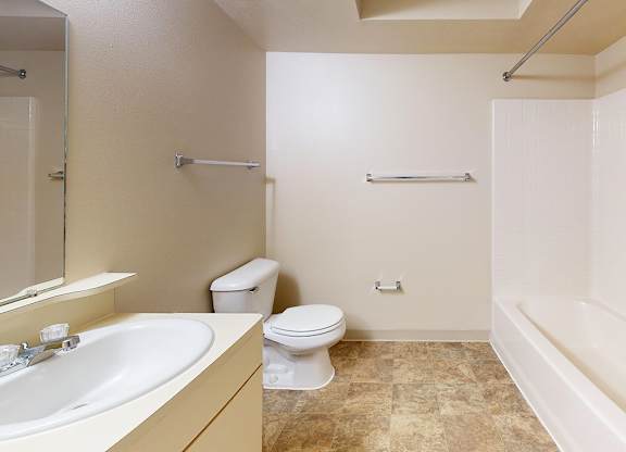 A bathroom with a toilet, sink, and bathtub at Gull Prairie/Gull Run Apartments and Townhomes, Kalamazoo, Michigan
