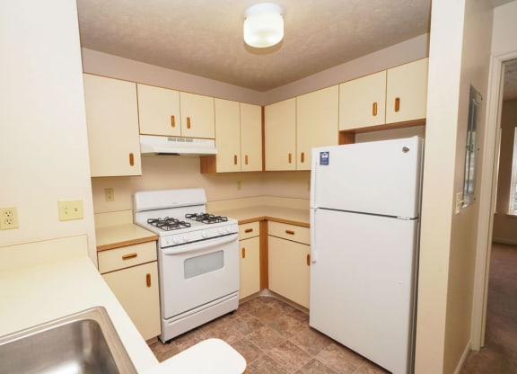 Two bedroom kitchen with white appliances at Glenn Valley Apartments, Michigan