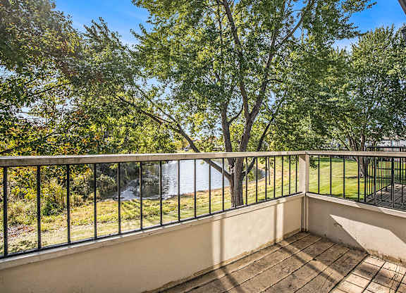 a balcony with a view of a pond and trees at Hampton Lakes Apartments, Michigan, 49534