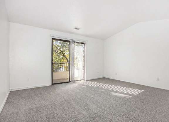 living room with a cathedral ceiling and sliding glass door to a balcony at Hampton Lakes Apartments, Michigan, 49534