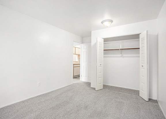 a bedroom with a closet with open doors at Hampton Lakes Apartments, Michigan, 49534