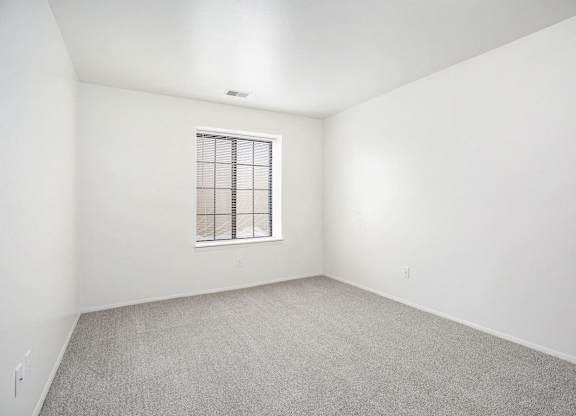a spacious bedroom with a window at Hampton Lakes Apartments, Michigan, 49534