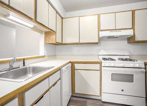 a kitchen with white appliances and wooden cabinets