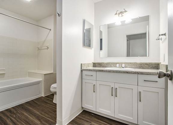 A white bathroom with a soaking tub, toilet, and sink at Foxwood and The Hermitage, Portage, MI, 49024