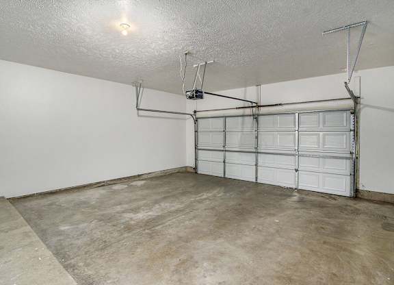 An attached garage with a white wall and a white door at Foxwood and The Hermitage, Portage, MI, 49024