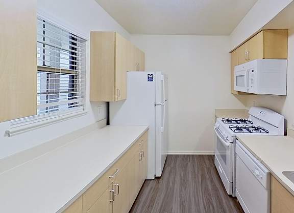 A kitchen with white appliances and wooden cabinets at Foxwood and The Hermitage, Portage, MI, 49024