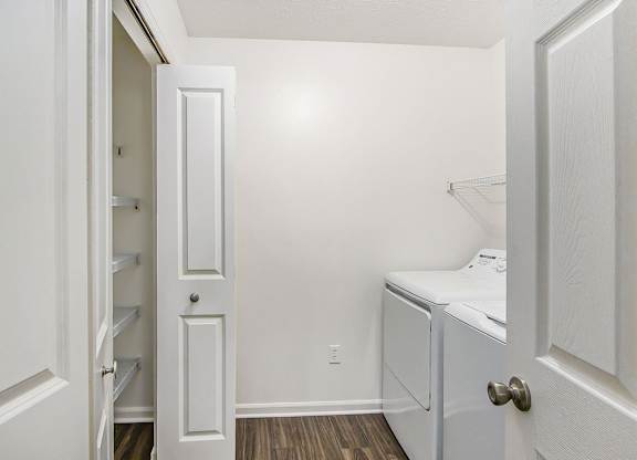 A white laundry room with a washer and dryer and a closet at Foxwood and The Hermitage, Portage, MI, 49024