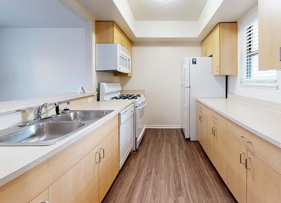 A kitchen with wooden cabinets and a white appliances at Foxwood and The Hermitage, Michigan