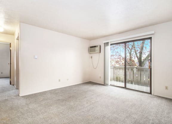 a living room with a sliding glass door and a balcony at Hickory Village Apartments, Mishawaka, IN, 46545