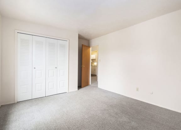a bedroom with a closet and a door to a bathroom at Hickory Village Apartments, Mishawaka, 46545