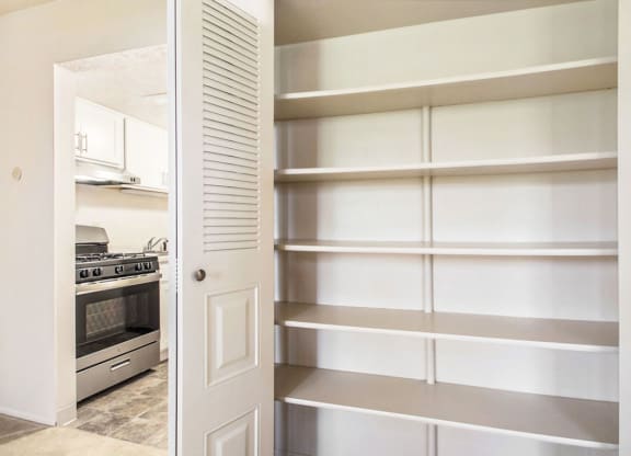 a kitchen with a white door and white shelves at Hickory Village Apartments, Indiana, 46545