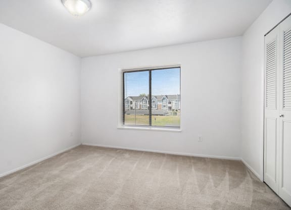 an empty living room with a large window at Hurwich Farms Apartments South Bend, IN