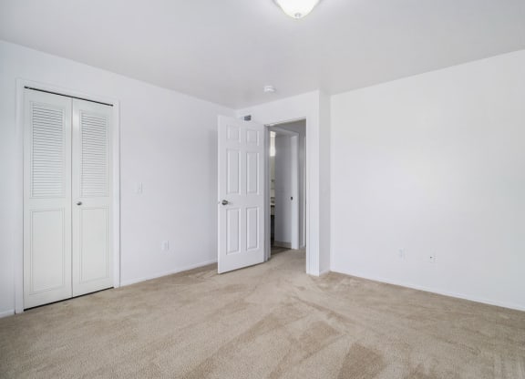 an empty living room with white walls and a door to a hallway at Hurwich Farms Apartments, Indiana