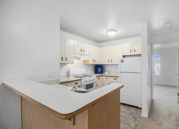 a kitchen with white cabinets and a white refrigerator at Hurwich Farms Apartments South Bend, IN