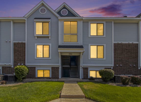 the front of an apartment building at dusk at Hurwich Farms Apartments, Indiana