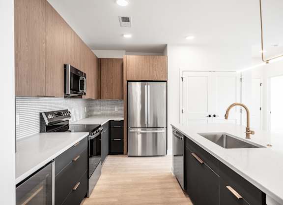 A modern kitchen with dark wood cabinets and stainless steel appliances.