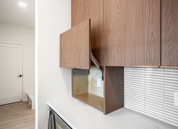 A white door is in a hallway with a white wall and a wooden cabinet.