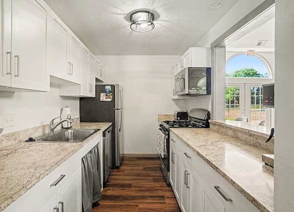 A kitchen with white cabinets and stainless steel appliances at Indian Lakes Apartments, Mishawaka, Indiana