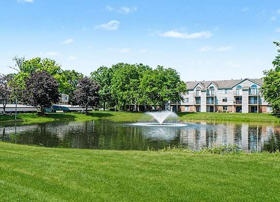 A fountain in the middle of a pond in front of a building at Indian Lakes Apartments, Mishawaka, Indiana