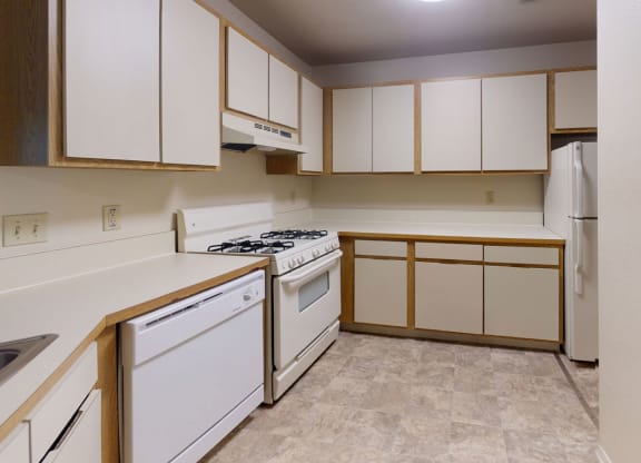 Kitchen with white appliances and stackable washer/dryer at Indian Lakes Apartments, Mishawaka