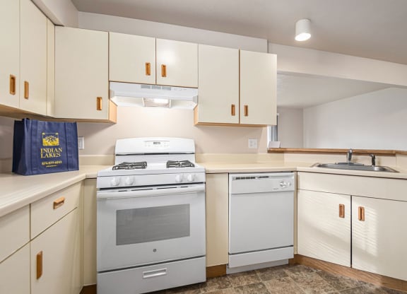 a kitchen with a breakfast bar at Indian Lakes Apartments, Mishawaka