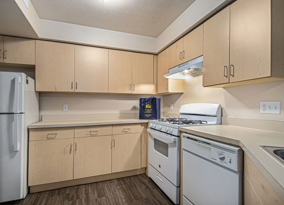 a kitchen with white appliances and wooden cabinets at Indian Lakes Apartments, Mishawaka