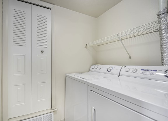 a white laundry room with a washer and dryer and a closet at Indian Lakes Apartments, Mishawaka