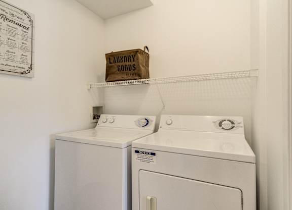 Two white front loading washing machines in a laundry room  at Northport Apartments, Macomb, MI, 48044