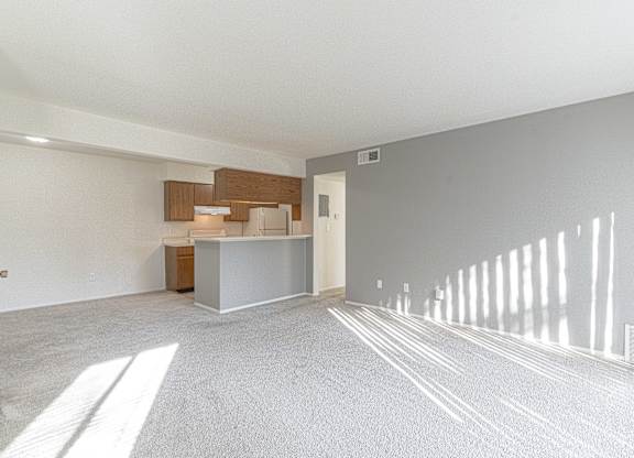A spacious room with a reception desk and a white wall.