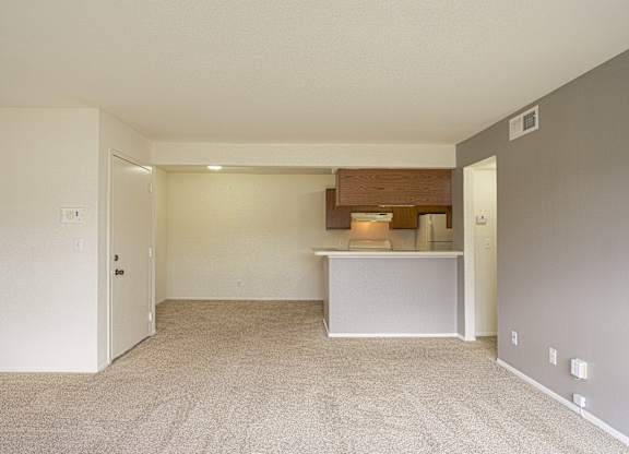 A large, empty room with a carpeted floor and white walls.